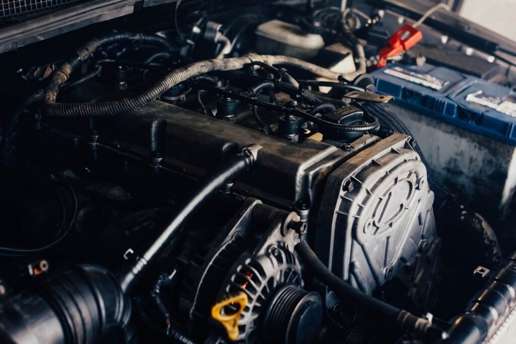 Close-up of a car engine leak repair with wires and components under the hood.